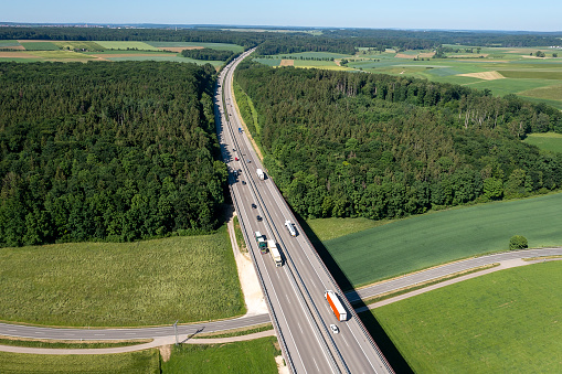 Aerial view of a rural highway bridge with speeding trucks and cars.