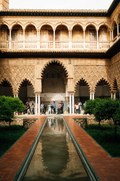 Seville, Spain - March 19, 2024: tourists are visiting Seville Alcazar, Spain. The Royal Alcazar of Seville at the Courtyard of the Maidens.