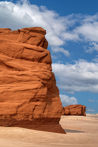 The red cliffs and beach of Havre aux Maisons, on the Gulf of St Lawrence, Iles de la Madeleine, Canada. Summer sky background.