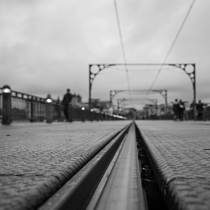 Detail of the subway railway tracks and electric cables on the superior deck of the Dom Luis I bridge connecting Vila Nova de Gaia to the city of Porto. Black and white