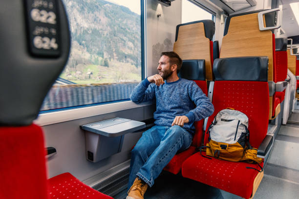 istock Relaxed male commuter looking outside a train's window 2148365724