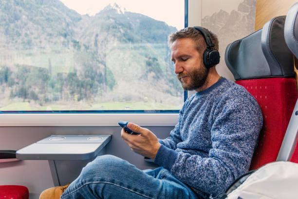 istock Young man on a train listening to music on his mobile device 2148365769