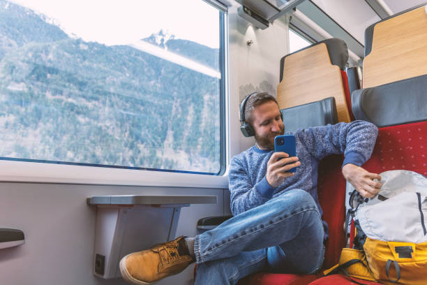 istock Man sitting on a train reaching into his bag by his side 2148365799