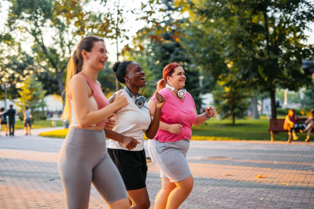 istock Three Young Female Friends Jogging In The Park 2148365926