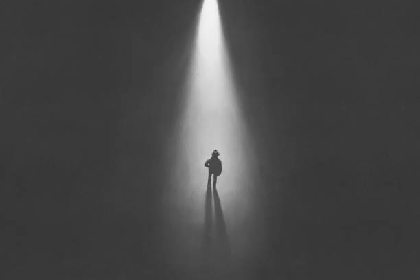 istock illustration of man walking in the night toward a cone of light, surreal conceptual 2148365960
