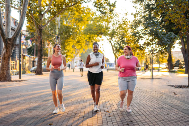 istock Three Young Female Friends Jogging In The Park 2148365961