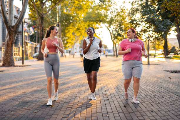 istock Three Young Female Friends Jogging In The Park 2148366004