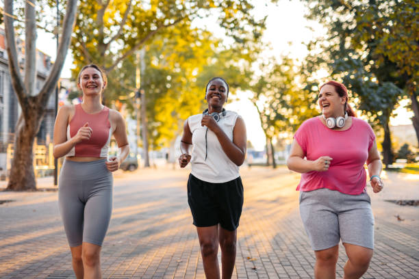 istock Three Young Female Friends Jogging In The Park 2148366332