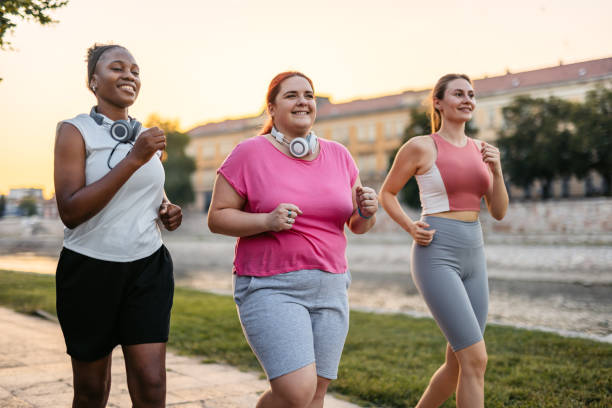 istock Three Young Female Friends Jogging On The Quayside 2148366345