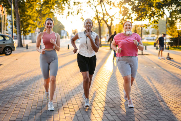 Three Young Female Friends Jogging In The Park
