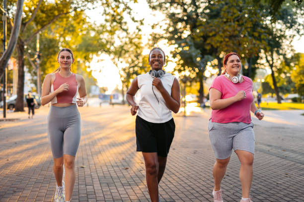 istock Three Young Female Friends Jogging In The Park 2148366597