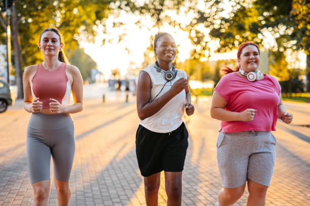 istock Three Young Female Friends Jogging In The Park 2148366665
