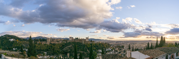 Panorama of fortress of Alhambra on a hill top seen from the quarter Albaicin with mountains of Sierra Nevada in background, Granada, Andalusia, Spain