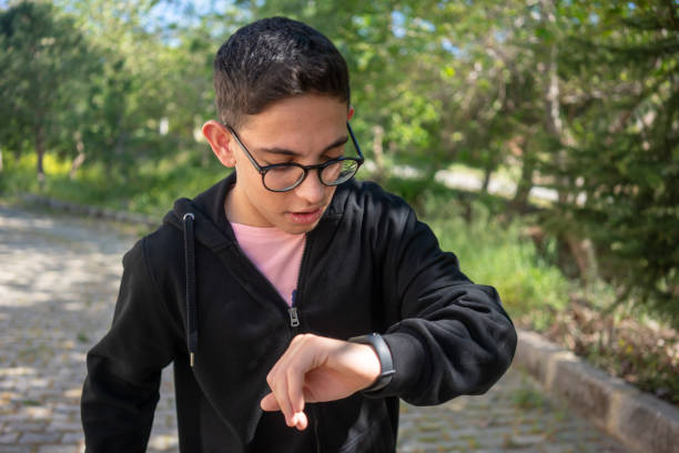 teenage boy is looking smart watch horizontal still