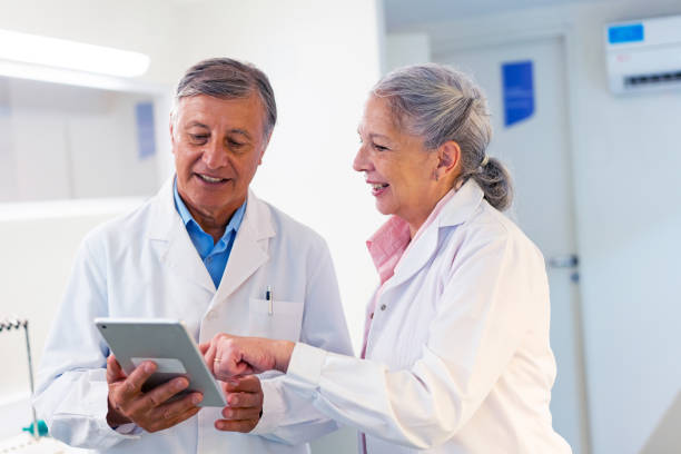 istock Senior Medical Professionals Discussing on Tablet in Lab 2148367860