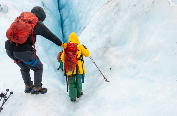 istock Tourists helping each other and climbing down the glacier crevasse using ropes. Exit Glacier ice hiking. Alaska. 2148368473
