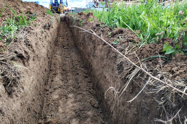 istock Construction excavator digging a shallow groove for electrical wiring or cable. 2148368897
