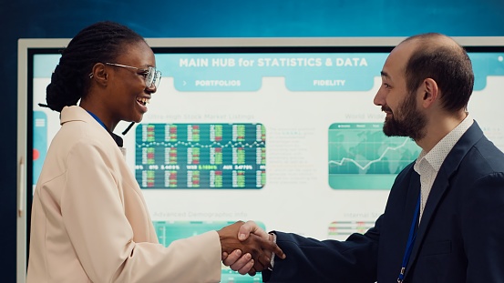 Businessmen handshaking in front of cyber visuals