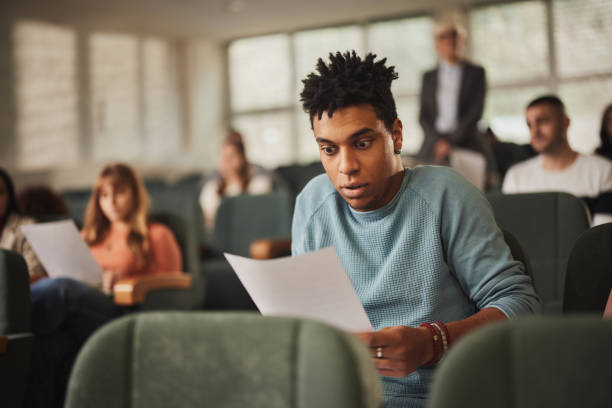 istock Shocked black student looking at his test results at lecture hall. 2148370670