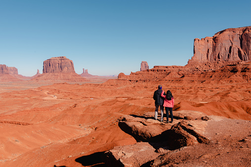 The tourists are admiring the view of West Mitten Butte in Monument Valley, USA, traveling during the winter in Arizona.