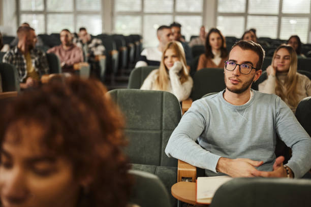 istock Young male student attending a class in amphitheater. 2148370846