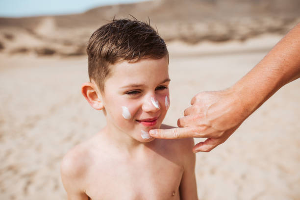 istock Boy with sunscreen lotion on face. Young boy si protected from sun with sunscreen. Concept of beach summer vacation with kids. 2148370993