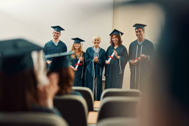 istock Proud senior professor and her awarded students on graduation in lecture hall. 2148371094