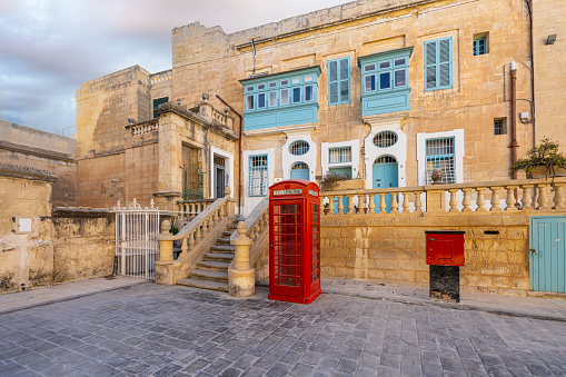 Valletta, Malta, April 02, 2024. The typical  phone booth and old houses in the historic center of the city