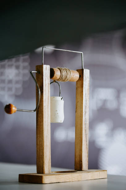 A golden yellow spool of thread is on the old hand spindle, ready to be worked into a textile