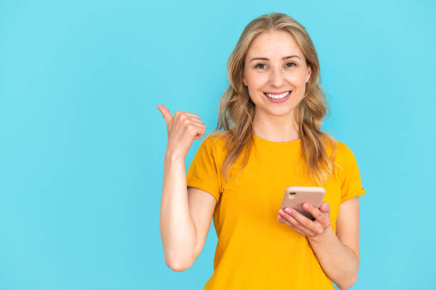 istock Smiling woman using mobile app and showing place for advertising, 2148373188