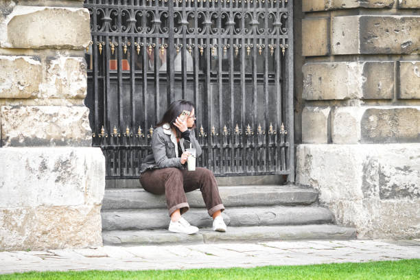 Girl reads a book sitting on a wall