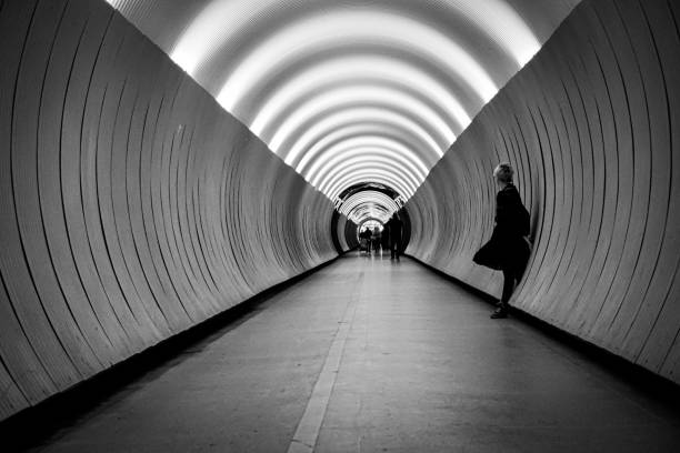 A woman standing against a wall in a tunnel