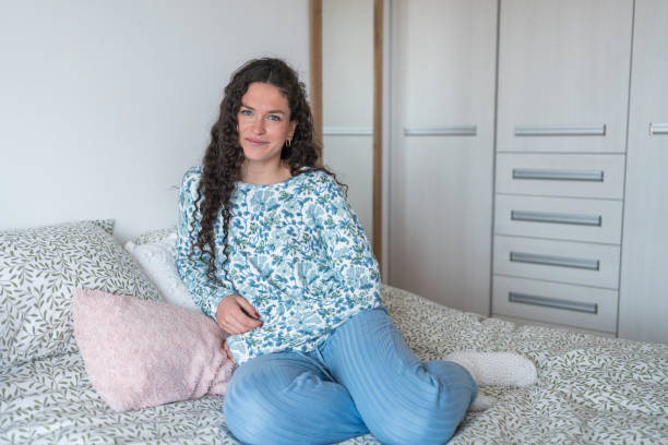 istock Woman sitting on bed in the morning 2148374476