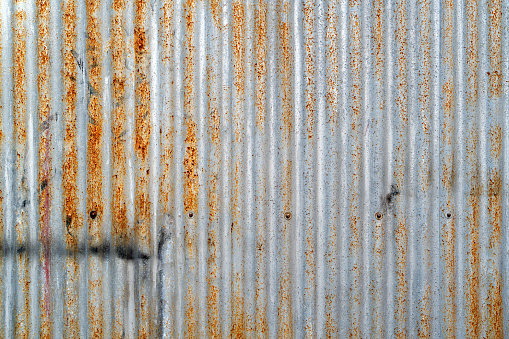 Weathered and rusted corrugated galvanized iron fence background