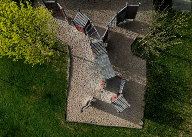 istock climbing wall on the playground in the park. solid beams with climbing handles in the form of colored stones made of composite material for bouldering, overhanging, bridge, tunnel, blue sky 2148378590