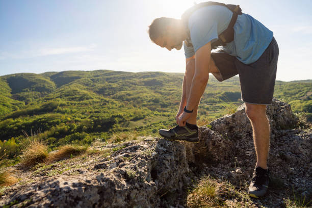 Trail runner preparing for a sports training on a rocky mountain trail.