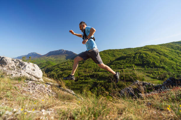istock Man running over the rocky mountain trail 2148379227