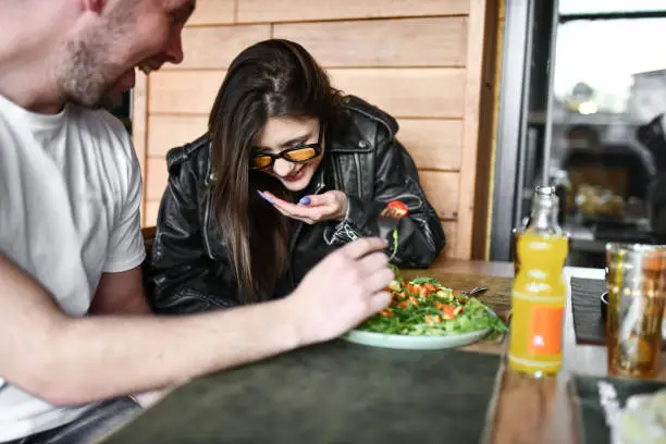 Photo of Female Spitting Out Food While Laughing With Boyfriend And Friends