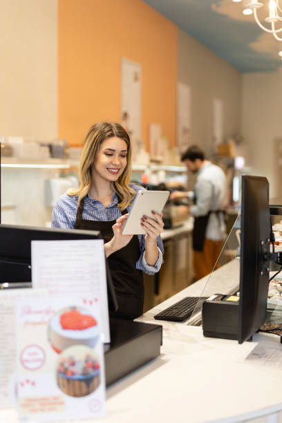 istock Smiling young baker at the checkout counter. 2148381135