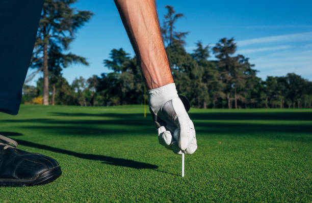 istock Golfer puts the golf ball on a tee 2148383661