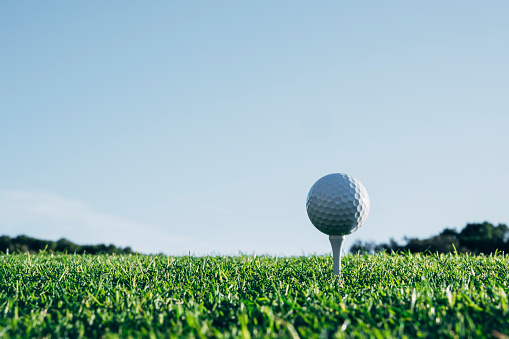 Golf ball with golf club on golf course, close up, no people,