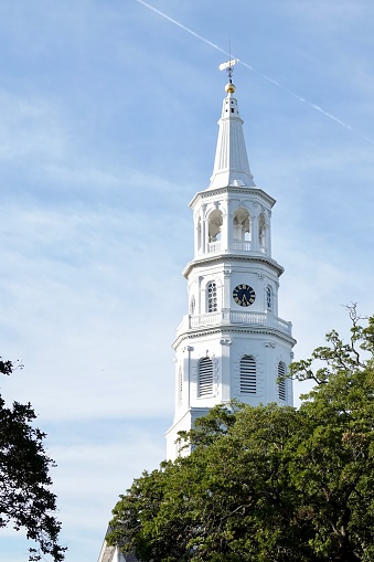 Steeple with a weather vane in bright sunlight and blue skies in Charleston, SC.