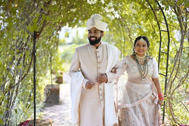 istock The bride and groom walk hand in hand under a beautiful green arch 2148384893