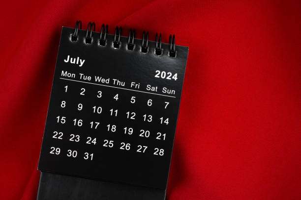 istock July 2024 Black spiral desktop calendar on textile. 2148385544