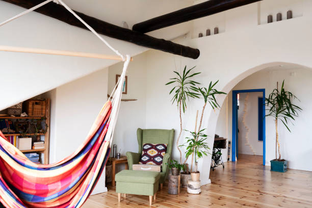 istock Comfortable libiving room in boho style with white wall with arch, hammock and wooden floor. Indoors architecture. 2148385580