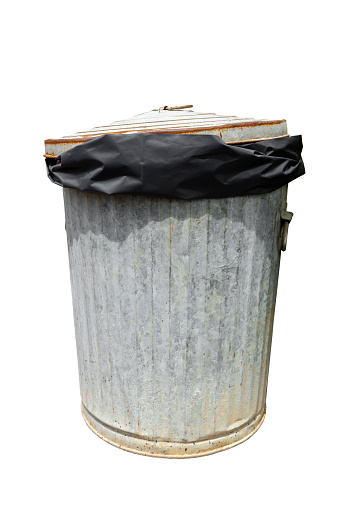 Rusty old trash with black plastic bag can isolated on white with a clipping path.
