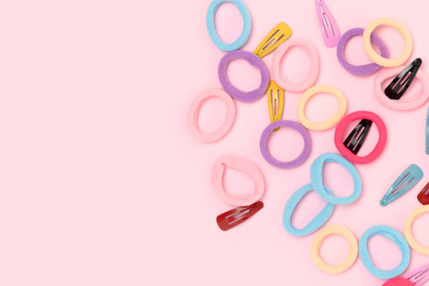 istock Small multicolored hair scrunchies and clips on a pink background. 2148385844