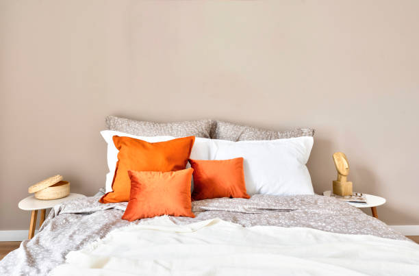 istock Bed in interior bedroom with bedclothes and orange pillow with blank wall. Home interior with modern design. 2148386710