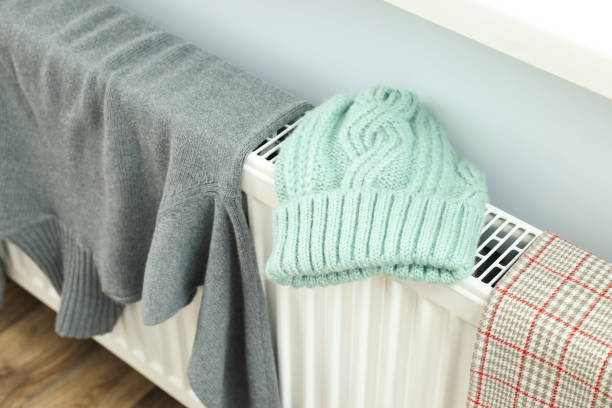 istock Different winter clothes drying on radiator indoor 2148388781