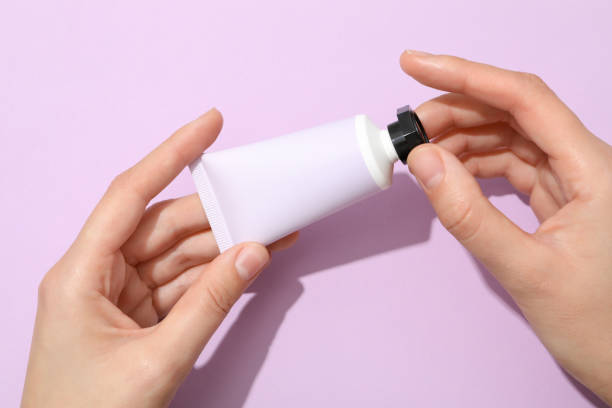 istock A jar of hand cream on a light, purple background. 2148389044